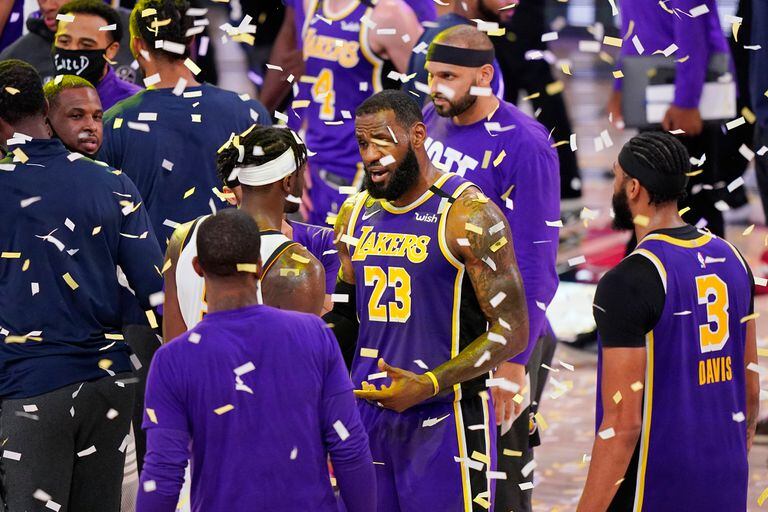 LeBron James (23) de Los Angeles Lakers habla con jugadores mientras cae confeti después de que los Lakers vencieron a los Denver Nuggets en un juego de baloncesto de playoffs de la conferencia de la NBA el sábado 26 de septiembre de 2020 en Lake Buena Vista, Florida. Los Lakers ganaron 117- 107 par