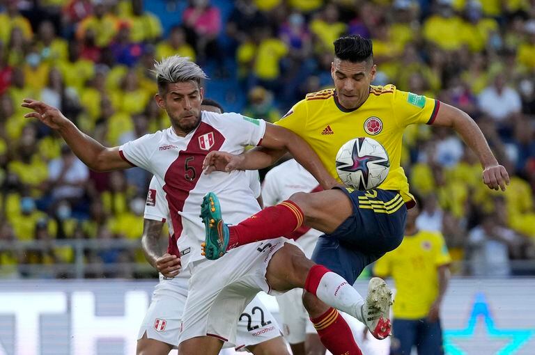 Colombia's Radamel Falcao Rodriguez, right, and Peru's Carlos Zambrano battle for the ball during a qualifying soccer match for the FIFA World Cup Qatar 2022 at Roberto Melendez stadium in Barranquilla, Colombia, Friday, Jan. 28, 2022. (AP Photo/Fernando Vergara)