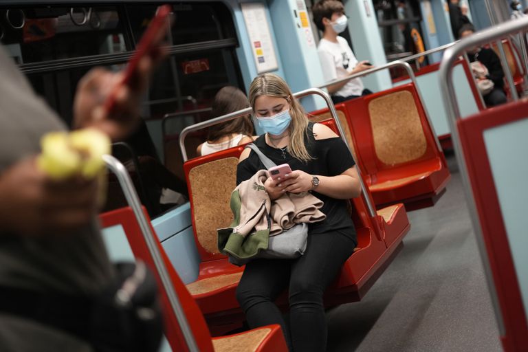 Una mujer usa su celular en un tren del metro en Lisboa