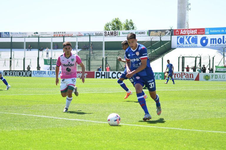 Lucas Esquivel va hasta el fondo y tira el centro durante el partido entre Sarmiento y Unión disputado en Junín; lo observa Sergio Quiroga. 