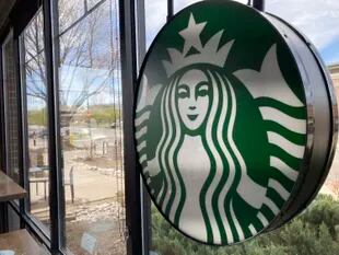 Un letrero con el logotipo de Starbucks en la ventana de una de las cafeterías de la compañía en Denver, el lunes 26 de abril de 2021. (AP Foto/David Zalubowski)