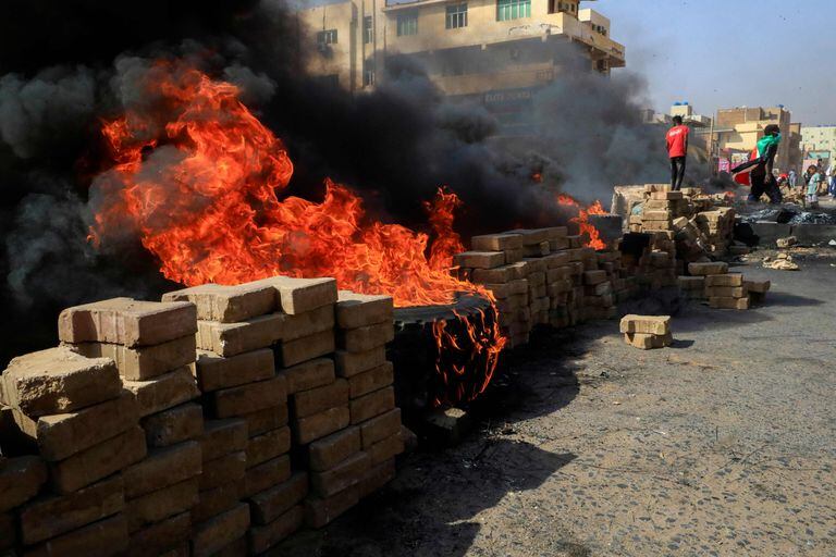 Manifestantes sudaneses queman neumáticos para bloquear una carretera en la calle 60 en la capital, Jartum, para denunciar detenciones nocturnas por parte del ejército de miembros del gobierno de Sudán