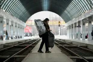 Un hombre lleva su equipaje mientras espera un tren a Rumania en la estación de tren de Chisinau, Moldavia, el martes 8 de marzo de 2022.