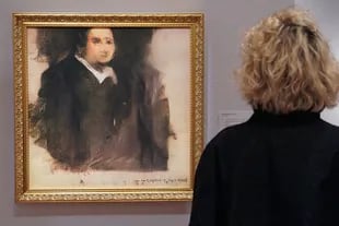 Una mujer mira una obra de arte creada por un algoritmo del colectivo francés OBVIOUS que produce arte usando inteligencia artificial, titulado "Retrato de Edmond de Belamy", en Christies en Nueva York.