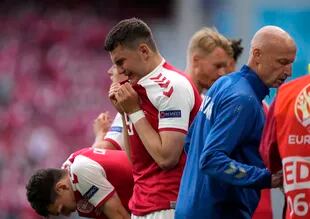 Los jugadores de Dinamarca lloran mientras Christian Eriksen recibe atención médica después de colapsar durante el partido ante Finlandia