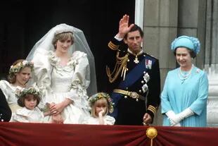 UNA NUEVA PRINCESA EN PALACIO. En julio de 1981, el príncipe
Carlos se casó con Lady Diana Spencer. En la imagen se la ve a Su Majestad junto a su hijo, su flamante nuera y las damas de honor saludando al pueblo desde el balcón del Palacio de Buckingham.