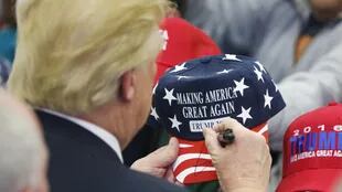 Donald Trump firma gorras a sus seguidores