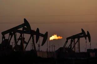 Una llama quema el metano y otros hidrocarburos mientras las bombas de extracción de petróleo operan en la Cuenca Pérmica en Midland, Texas, el 12 de octubre de 2021. 