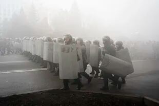 Policías antidisturbios bloquean a manifestantes durante una protesta, el miércoles 5 de enero de 2022, en Almaty, Kazajistán.  (AP Foto/Vladimir Tretyakov)