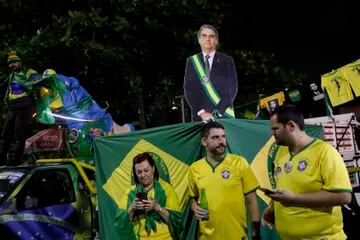 Los partidarios del presidente brasileño Jair Bolsonaro, quien se postula para otro mandato, siguen los resultados parciales luego de que cerraron las urnas para las elecciones generales frente a su casa en Río de Janeiro, Brasil, el domingo 2 de octubre de 2022. (Foto AP/Bruna Prado)