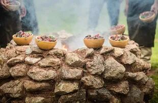 El equipo de Mil cocina preparando huatia, plato típico de la gastronomía andina.