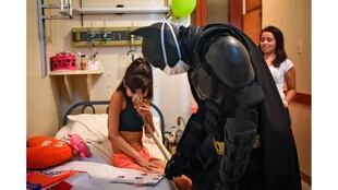 Una foto tomada a través de un vidrio muestra a Florencia Aguero jugando con Batman