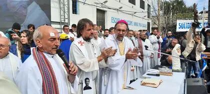 Los padres Lorenzo "Toto" de Vedia y José María "Pepe" Di Paola, junto al obispo Gustavo Carrara, en la misa de desagravio a Francisco, en la parroquia Virgen de los Milagros de Caacupé, de Barracas