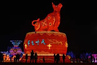 La gente mira una linterna de buey gigante en un parque en Wuhan, en la provincia central china de Hubei en 2021