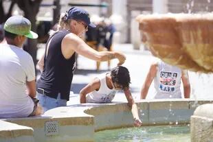 07/07/2022 Una madre le echa agua a su hijo, por la cabeza, en la fuente de la plaza Virgen de los Reyes en el primer día de la segunda ola de calor, a 7 de julio de 2022 en Sevilla (Andalucía, España) SALUD Joaquin Corchero - Europa Press