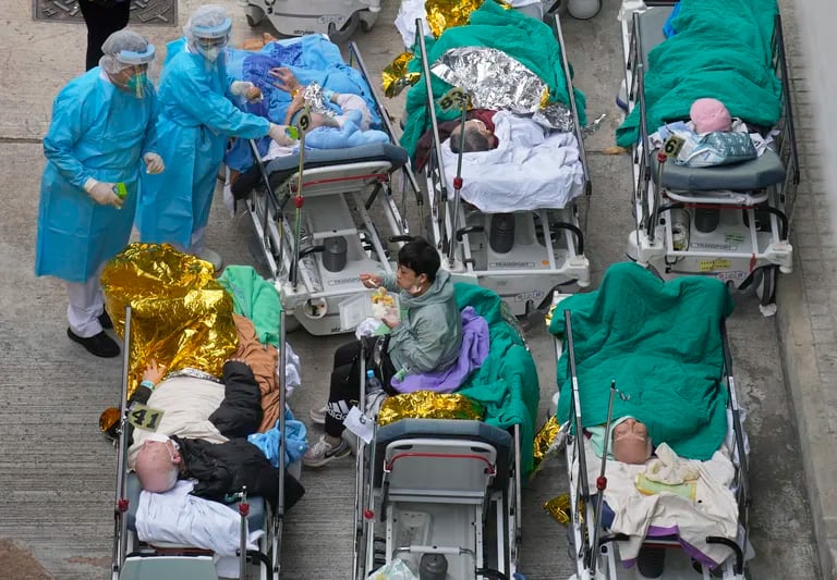 I pazienti aspettano sulle barelle dell'ospedale in un'area di attesa fuori dal Caritas Medical Center di Hong Kong, mercoledì 16 febbraio 2022. Ci sono stati chiari segnali che la nuova ondata di COVID aveva superato gli ospedali di Hong Kong, quando i pazienti sulle barelle e le tende del personale medico si sono presentati fuori dall'ospedale Caritas.  (Foto AP Vincent Yu)