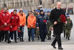 Putin walks to lay flowers at the monument dedicated to Citizen Minin and Prince Pozharsky on National Unity Day in Red Square