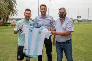Lionel Messi le regala una camiseta autografiada a Santiago Carreras, el hombre de Máximo Kirchner en el mundo del fútbol; los acompaña Claudio Tapia, presidente de la AFA