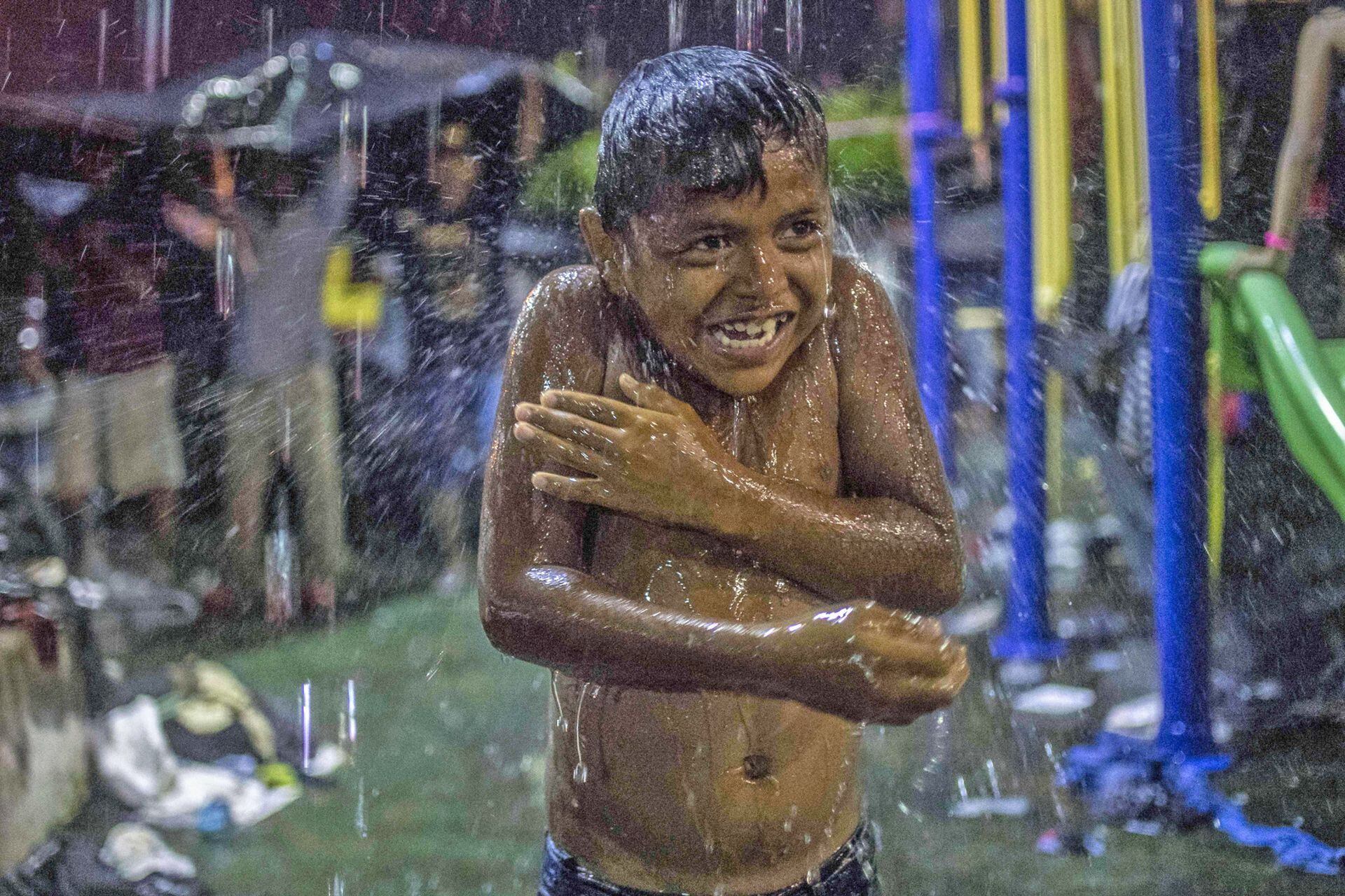 Un niño juega bajo la lluvia en Mapastepec, estado de Chiapas, México