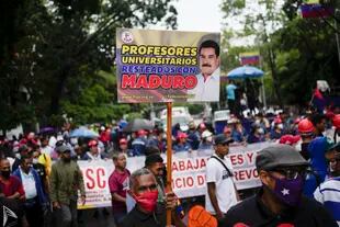 Un maestro sostiene un cartel durante una protesta de trabajadores públicos que exigen que el gobierno pague todos sus beneficios y respete los convenios colectivos en Caracas, Venezuela, el miércoles, 10 de agosto de 2022. 