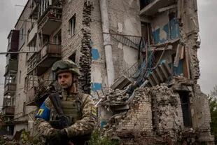 Un soldado ucraniano delante de un edificio de viviendas destruido en Izium. (Nicole Tung/The New York Times)