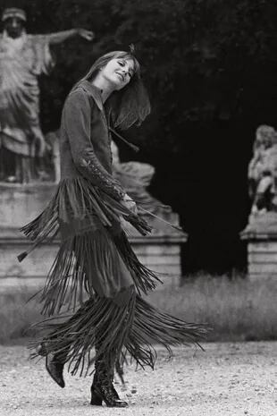 Con un vestido de gamuza, con cordones y flecos de Ossie Clark y botas haciendo juego de François Villon, Jane baila para el fotógrafo.