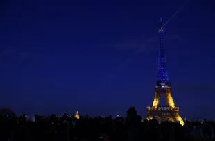 Esta fotografía tomada en París, el 25 de febrero de 2022, muestra la Torre Eiffel iluminada en azul y amarillo, los colores de la bandera ucraniana.