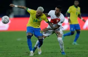 Neymar, de Brasil, y Sergio Peña, de Perú, disputan un balón durante un partido de la Copa América en el Estádio Nilton Santos de Río de Janeiro, el jueves 17 de junio de 2021 (AP Foto/Silvia Izquierdo)