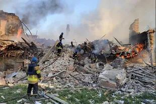 Esta fotografía publicada por el Servicio Estatal de Emergencias de Ucrania el 8 de mayo de 2022, muestra a los bomberos ucranianos apagando un incendio después de que los misiles rusos alcanzaran una escuela en la región de Lugansk, en el este de Ucrania, el 7 de mayo de 2022.