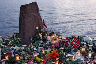 Frente a la isla de Utoya, flores y velas, en recuerdo de las víctimas