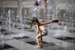 Una niña se refresca con chorros de agua en Brest, en el oeste de Francia, el 18 de julio de 2022