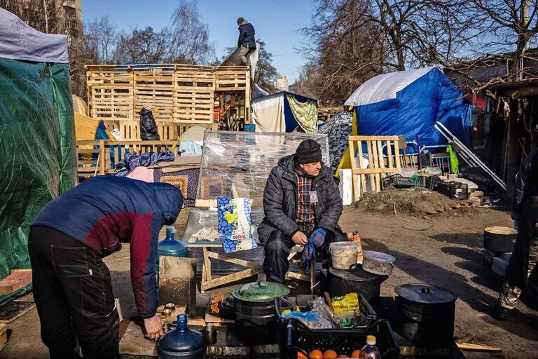 Volunteers prepare food for local residents and members of the Ukrainian Territorial Defence Forces at a field kitchen in Kyiv on March 11, 2022. - The capital Kyiv risks being surrounded, with Russian forces moving in on areas north and west of the capital, the Ukrainian military says, with some of its suburbs heavily bombarded. Three other major cities are effectively besieged. (Photo by Dimitar DILKOFF / AFP)