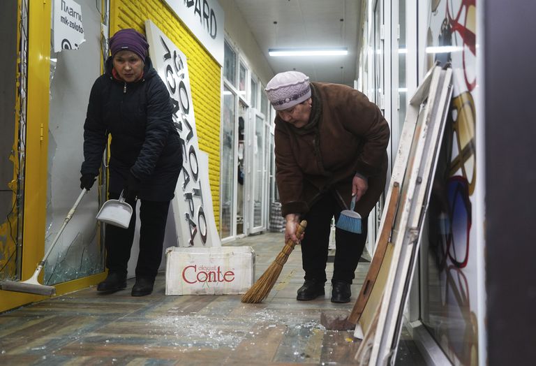 Vendedoras limpian un comercio saqueado durante los choques en Almaty, Kazajistán, el lunes 10 de enero de 2022.  (Vladimir Tretyakov/NUR.KZ via AP)