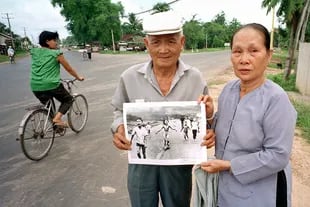 Años atrás, los padres de Kim Phuc posaron con la foto en la misma calle donde fue tomada originalmente