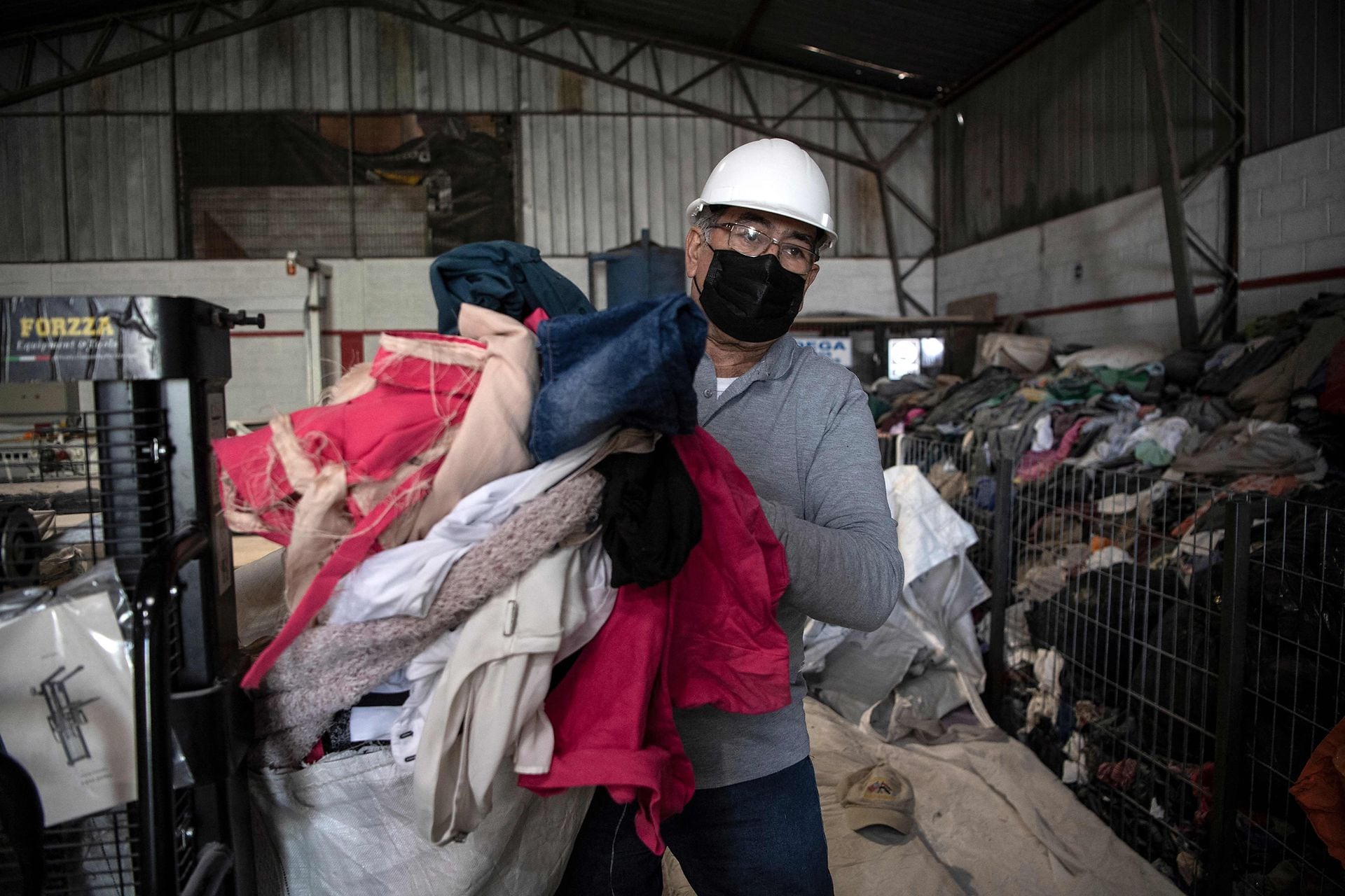 Un hombre trabaja en una fábrica que recicla ropa usada desechada en el desierto de Atacama 