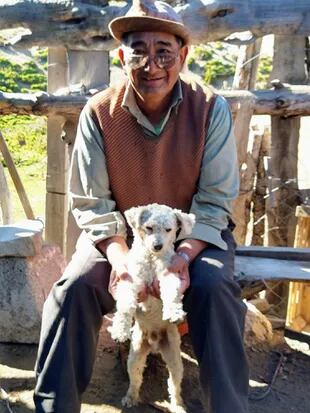 Don Oscar Maliqueo junto a su perro, las mascotas son muy frecuentes en los puestos. 