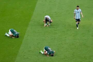 Lionel Messi (derecha) se retira de la cancha tras la derrota 2-1 en el debut; los árabes besan el suelo y rezan