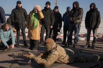 Valentyna Konstantynovska, de 79 años, se toca la cabeza mientras escucha instrucciones con otros sobre el manejo de armas durante un entrenamiento básico de combate para civiles, organizado por la Unidad de Fuerzas Especiales Azov, de la Guardia Nacional de Ucrania, en Mariupol, región de Donetsk, este de Ucrania