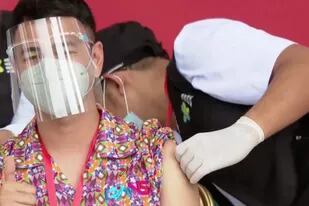 El influencer indonesio Raffi Ahmad gesticula mientras recibe una inyección de la vacuna contra la enfermedad del coronavirus en el Palacio Merdeka en Yakarta