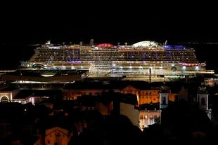 El crucero alemán AIDAnova permanece en Lisboa el viernes 31 de diciembre de 2021, poco antes de la medianoche. (AP Foto/Armando Franca)