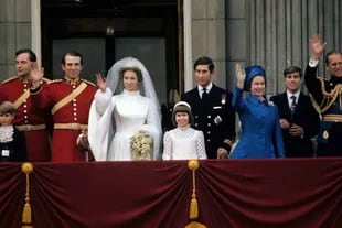 EL CASAMIENTO DE SU HIJA. Amazona estrella y atleta olímpica, la
princesa Ana y su compañero ecuestre, el capitán Mark Phillips, saludan en el balcón del Palacio de Buckingham tras su boda, celebrada en noviembre de 1973 en la abadía de Westminster.