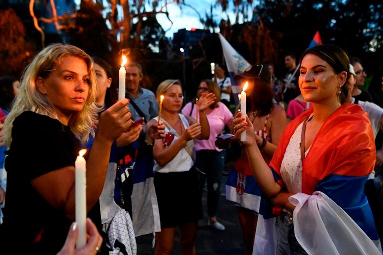 Members of the local Serbian community hold a vigil in front of the hotel where Novak Djokovic was staying