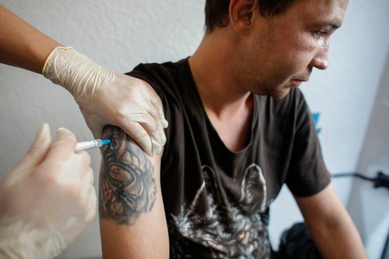 Stanislav, un hombre sin hogar, recibe una inyección de la vacuna de una dosis Sputnik Light en un puesto móvil de vacunación en San Petersburgo, Rusia, el miércoles 11 de agosto de 2021. (AP Foto/Elena Ignatyeva)