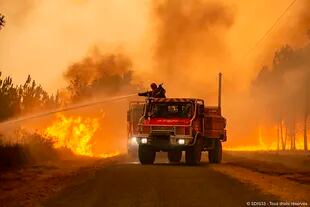 Esta foto proporcionada por el cuerpo de bomberos de la región de Gironda SDIS 33, (Servicio Departamental de Incendios y Rescate 33) muestra a los bomberos abordando un incendio cerca de Hostens, al sur de Burdeos, suroeste de Francia, el miércoles 10 de agosto de 2022.