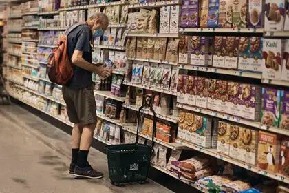 FILE - A person shops at a supermarket in New York, Wednesday, July 27, 2022.  Rising food prices in the US are reducing demand for home delivery.  Some consumers opt for cheaper services, while others go to grocery stores in person.  (AP Photo/Andreus Gutacki)