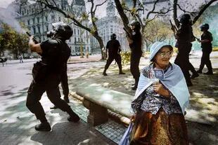 Una mujer sostiene una imagen de Eva Perón durante los enfrentamientos entre manifestantes y la policía, el 20 de diciembre de 2001, en Plaza de Mayo