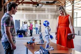 La reina Máxima de los Países Bajos habla con un robot durante una visita a una planta en Apeldoorn