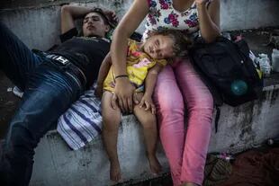 Migrantes hondureños descansan durante una parada en su viaje, en Huixtla