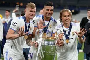 Toni Kroos, Casemiro y Luka Modric celebran con el trofeo de la última Champions League que ganaron con Real Madrid, en junio pasado, luego de vencer a Liverpool en la final, en París