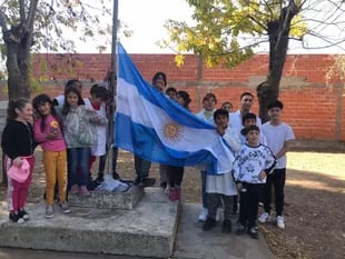 Rodeado por sus compañeros y acompañado por su Directora y su profesor, Nicolás izó la bandera en la escuela (Foto: Gentileza / Semana maipuense)